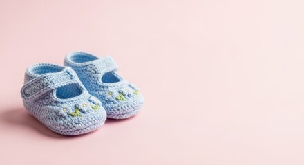 Adorable baby booties featuring delicate floral embroidery on a soft pink background perfect for...