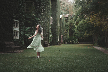 Teenage girl twirling in lush garden serene nature scene playful lifestyle outdoor viewpoint