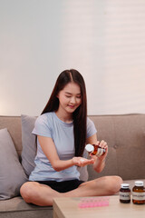 Young Asian Woman Preparing Daily Vitamins Supplements for Optimal Health and Longevity Lifestyle...