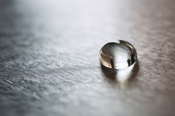 single water droplet resting on steel surface captured in macro detail
