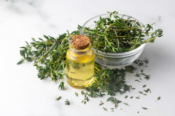 Bottle of thyme essential oil with fresh thyme