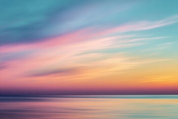 Obraz premium Pastel sunset ocean with blurred color streaks over calm sea horizon for minimalist digital wallpapers and wellness meditation templates. 