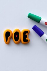 Orange Letters Forming Poe with Green and Purple Markers on White Background