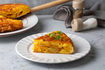 Spanish omelette with potatoes, typical spanish cuisine on gray concrete floor. Tortilla Espanola. Turkish name; Yumurtali patates