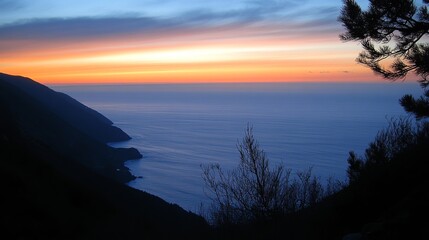 Breathtaking coastal sunset view from a mountaintop, showcasing a serene ocean meeting a dramatic silhouette of hills under a colorful sky