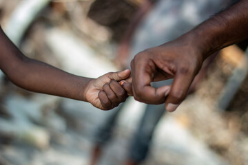 Father and daughter are playing with each other, holding each other's hands, and the background is...