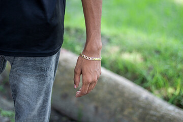 A young boy is wearing a chain on his hand