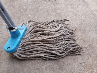 Old mop head on cement floor.