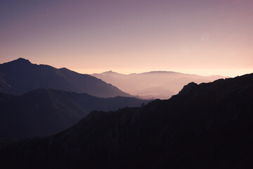 Morning light illuminating several layers of mountains in Corsica