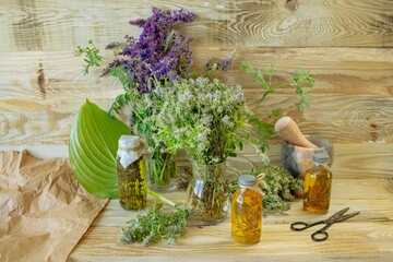 Herbs, spices, tinctures and vegetable oils on a wooden background. Phytotherapy, alternative medicine.