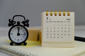 Monthly desk calendar for July 2025 on an office background. 