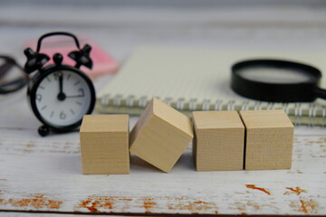 wooden blocks scattered on the wooden table with wooden figures as a people concept. 