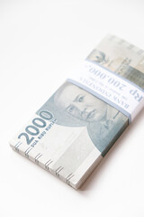 A stack of Indonesian rupiah Rp 2.000 banknotes isolated on white background for THR on Eid al-Fitr or Lebaran days