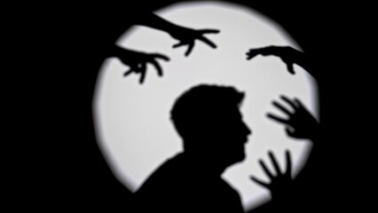 Silhouette of Person Surrounded by Reaching Shadows