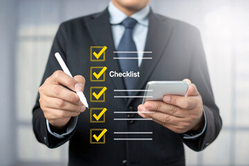 Businessman holding a smartphone and pen checking off items on a digital checklist isolated on white background