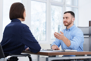 Recruiter and candidate having job interview at desk in office