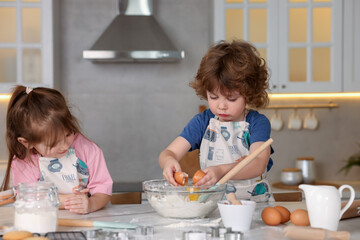 Cooking recipe. Cute children making dough for cookies at table in kitchen