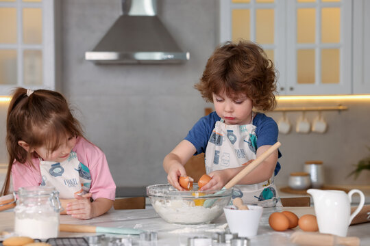 Cooking recipe. Cute children making dough for cookies at table in kitchen
