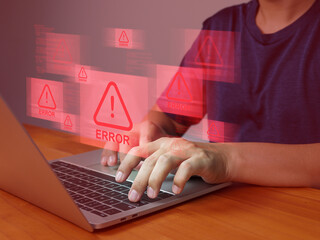 Person typing on laptop with multiple red error warning signs floating above keyboard, indicating...