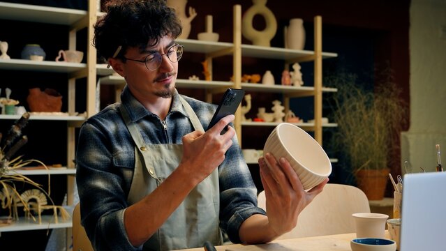 Small business owner Caucasian man guy artist potter salesman blogger influencer mobile phone photo male sculptor craft sale online blog ceramics sell online social media handmade in pottery workshop