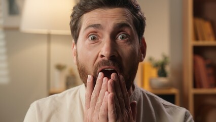 Shocked man portrait scared guy looking at camera amazing reaction shock frightened at home...