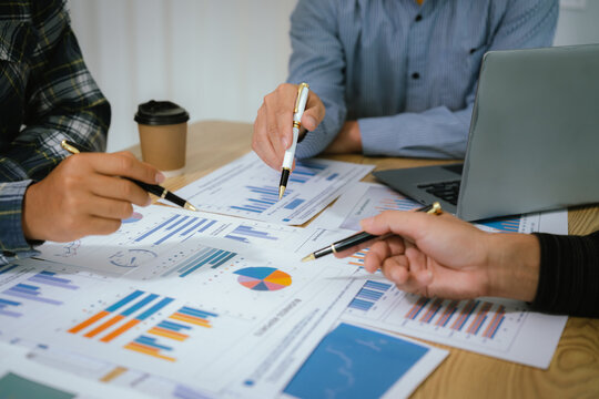 A professional business team collaborates around a conference table, analyzing charts, discussing strategies, reviewing reports, and planning innovative solutions to drive growth, efficiency, and long - Powered by Adobe