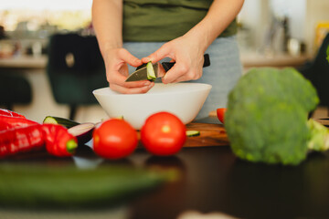 Woman cutting fresh vegetables in the kitchen. Healthy cooking, food preparation and lifestyle...