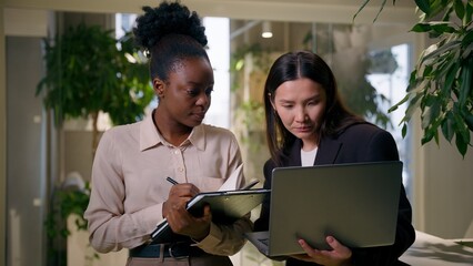 African Asian business women girls colleagues multiracial businesswomen in office teamwork laptop...