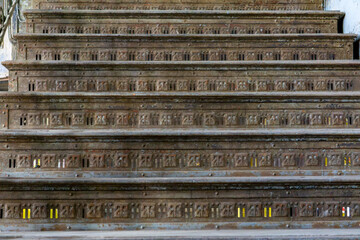 old metal stairs with a decorative perforated pattern, showing signs of rust and wear from long-term use. Industrial or historical detail.
