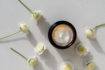 Cosmetic cream in container for face and body skin care top view. Natural organic product in glass jar for wellness, beauty and spa.