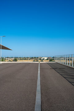 Contemporary empty road with sharp linear markings and open sky, evoking clarity, minimalism, and structured urban space