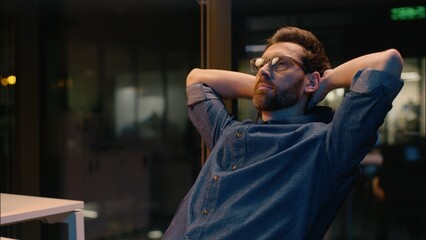 Obraz premium Caucasian business man businessman finish online working overtime end computer job complete task overworked tired employer guy male in night evening office relaxing hands behind head pause relaxing
