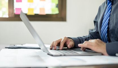 The businessman hand sits at their desks and calculates financial graphs showing the results of...