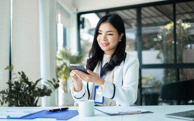 Female CEO in casual wear smiling and using Smartphone working Shown on the digital screen analyze...