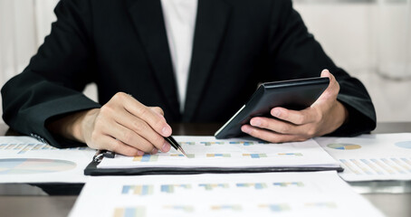 Asian businessman sit at their desks and calculate financial graphs showing results about their investments, planning successful business growth process
