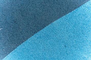 Diagonal split between dark blue and light blue textured playground flooring. A minimalist shot...