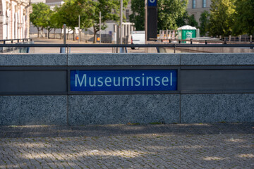 View of the Museum Island subway sign against a modern urban backdrop. The subway station is centrally located in Berlin and leads directly to Museum Island.