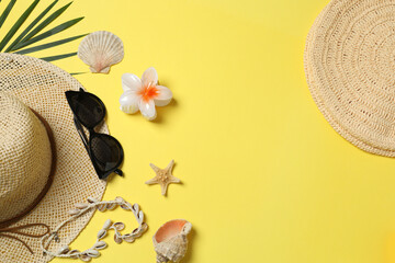 Tropical vibes shot from above. Straw hat, sunglasses, pineapple, wicker bag, beach accessories on...
