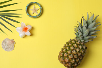 Tropical vibes shot from above. Straw hat, sunglasses, pineapple, wicker bag, beach accessories on...