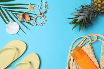 Tropical vibes shot from above. Straw hat, sunglasses, pineapple, wicker bag, beach accessories on...