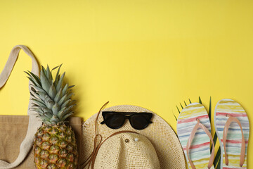 Tropical vibes shot from above. Straw hat, sunglasses, pineapple, wicker bag, beach accessories on...