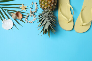Tropical vibes shot from above. Straw hat, sunglasses, pineapple, wicker bag, beach accessories on...