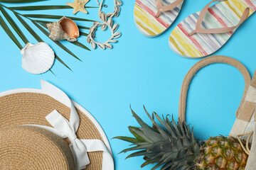 Tropical vibes shot from above. Straw hat, sunglasses, pineapple, wicker bag, beach accessories on...