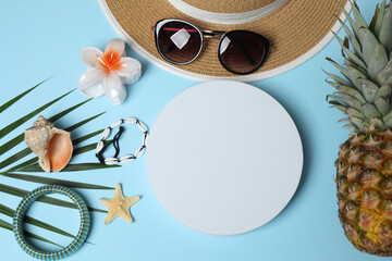 Tropical vibes shot from above. Straw hat, sunglasses, pineapple, wicker bag, beach accessories on...