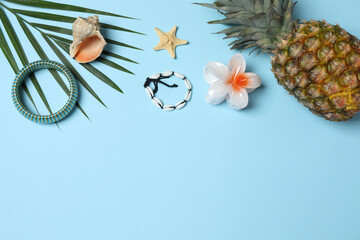 Tropical vibes shot from above. Straw hat, sunglasses, pineapple, wicker bag, beach accessories on...