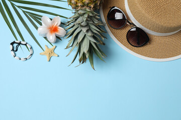 Tropical vibes shot from above. Straw hat, sunglasses, pineapple, wicker bag, beach accessories on...