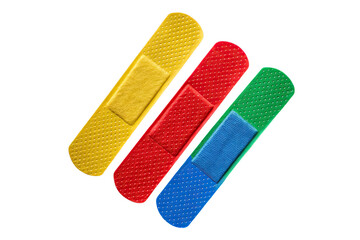 A close up of three colorful adhesive bandages arranged diagonally on a black background surface