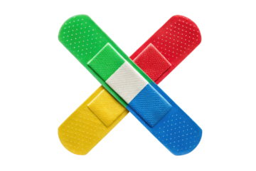 Colorful adhesive bandages in a criss cross pattern on a plain black background studio shot