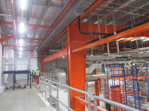 Worker on Mezzanine installing ventilation pipes - Powered by Adobe