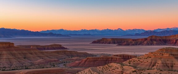 Naklejka premium A breathtaking view of a desert plain at sunset, surrounded by dramatic rugged mountains casting warm hues in a serene, picturesque setting, evoking tranquility and natural beauty.